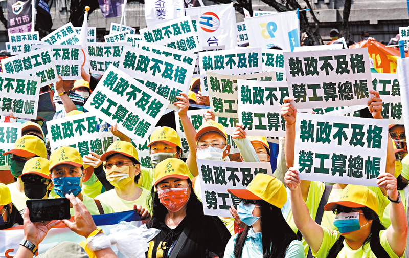 ◆5月1日下午在凱達格蘭大道上，參與遊行的勞工高舉標語，控訴蔡當局在近8年完全執政下勞工政策「不及格」。 中央社
