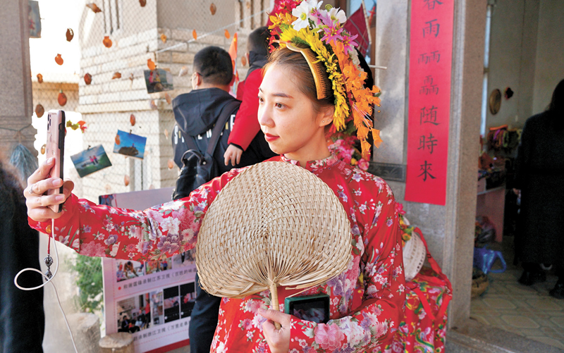 ◆戴起簪花圍、裝扮成蟳埔女的女生忙自拍。香港文匯報記者蔣煌基 攝