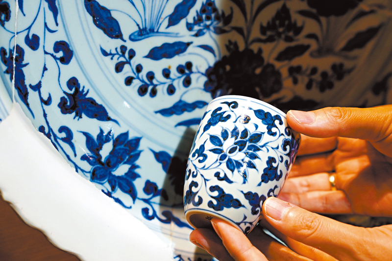 ◆蔡文娟展示她的青花文創產品。