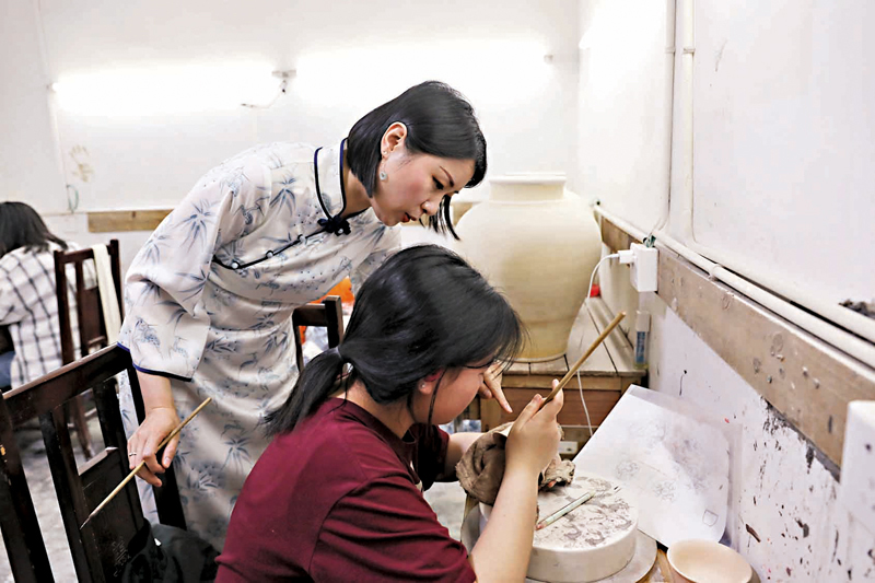 ◆蔡文娟指導學徒繪製青花圖案。
