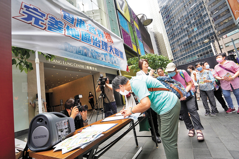 ◆在銅鑼灣街站，支持完善地區治理方案的市民排隊輪候簽名。香港文匯報記者曾興偉  攝