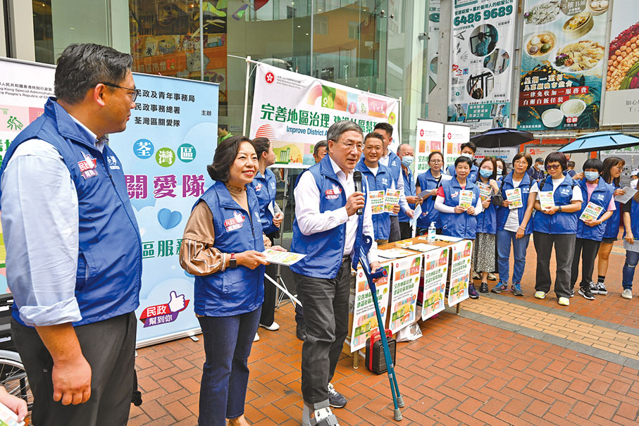 ◆ 政務司副司長卓永興（左三）、民政及青年事務局局長麥美娟（左二）及一眾嘉賓到訪荃灣區關愛隊聯合街站，一同向市民宣傳完善地區治理建議方案。