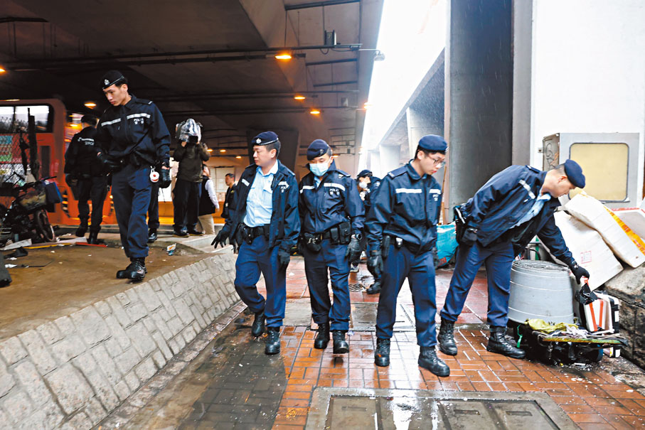 ◆警員在劫案現場附近搜索證物。香港文匯報記者劉友光  攝