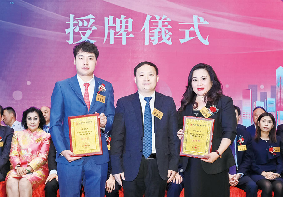 ◆ 化州市委常委、統戰部部長、麗崗鎮黨委書記黃勇文（中）頒授會牌予理事長李曉艷（右）及監事長李嘉晃（左）。