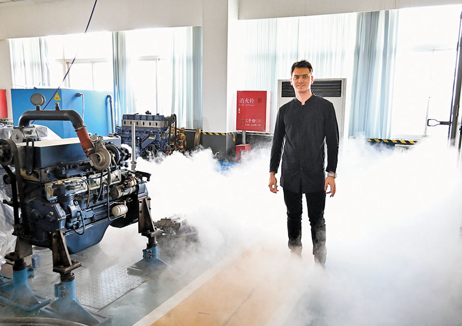 ◆2021年4月20日，土庫曼斯坦留學生撒普爾在北京一家企業調研，了解空氣壓縮發動機。 新華社