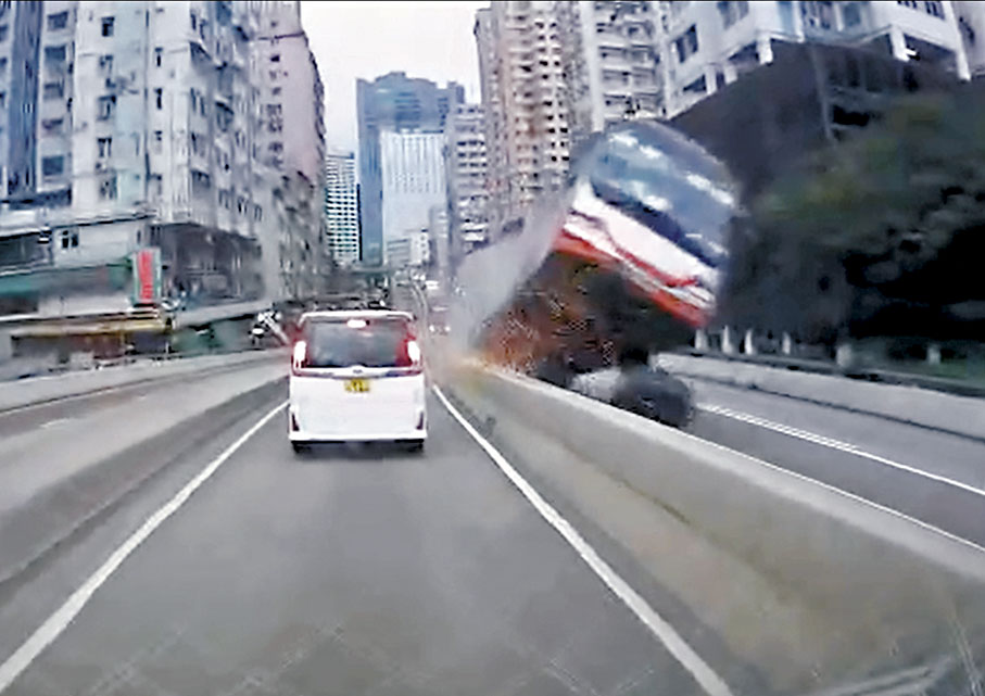 ◆失事旅遊巴撞向路中石壆斜台後「起跳」，整車彈飛翻側橫亘路中。 車cam片段截圖
