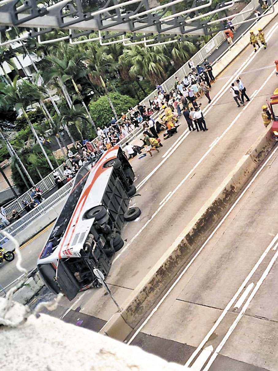 ◆旅遊巴失事翻側路中，消防員到場拯救，部分傷者在路邊待救。 網上圖片