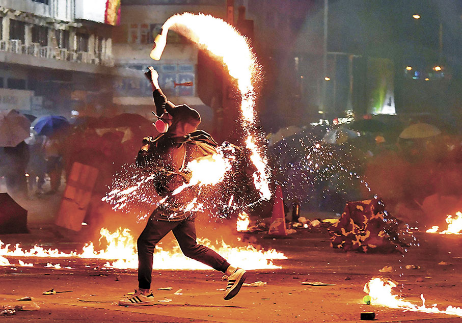 ◆2019年11月18日，暴徒於油麻地加士居道一帶瘋狂投擲汽油彈，及後警員冒着地面火勢展開驅散行動。 資料圖片