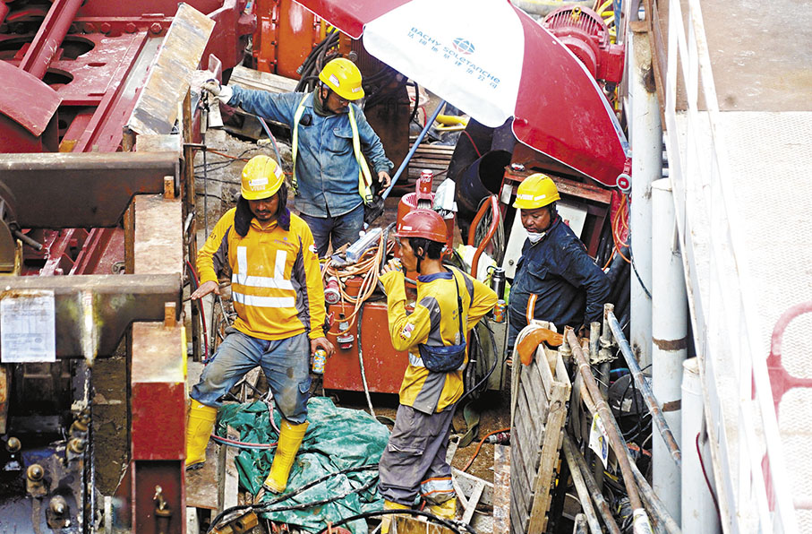 ◆在暑熱天氣下，工人在傘下喝着汽水休息。 香港文匯報記者曾興偉  攝