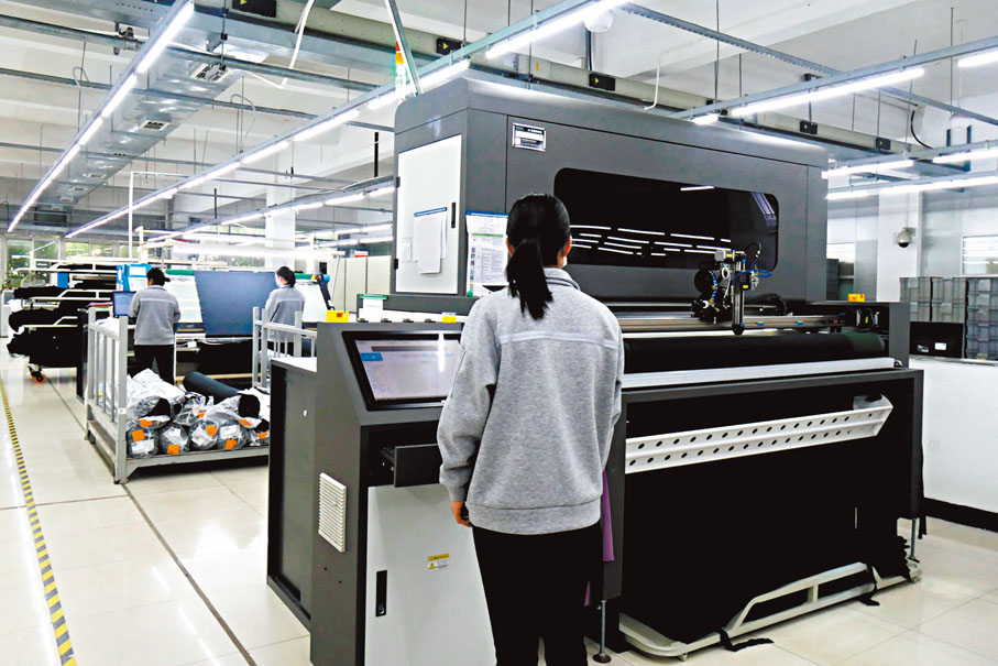 ◆在莎美娜製衣的車間，工人操作數字化生產設備。 香港文匯報記者賀鵬飛  攝