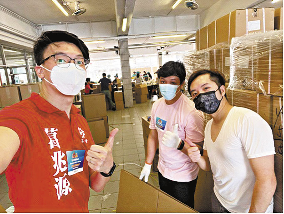◆筆者與荃灣區福來區關愛隊隊長葛兆源一同合作，埋首苦幹為區內居民包裝防疫服務包。 作者供圖