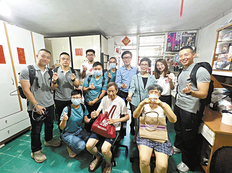 ◆青年義工和學警探望鍾伯伯（前排中）一家。 香港文匯報記者子京  攝