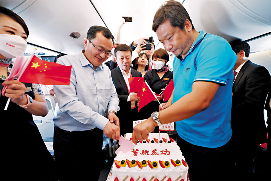 ◆旅客在飛機客艙內切下首航慶祝蛋糕。  中新社