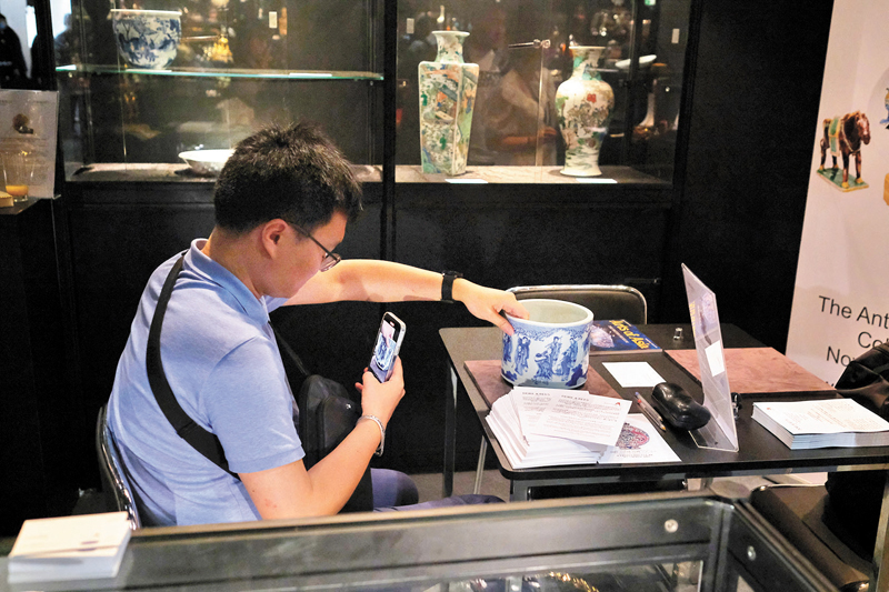 ◆藏家在認真觀察古玩。