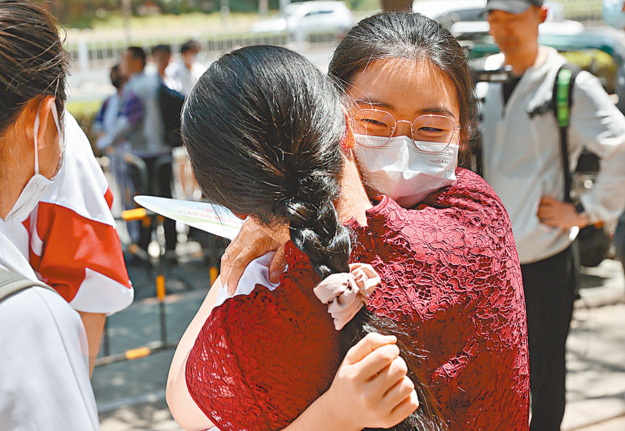 ◆6月7日，北京，中國人民大學附屬中學考點，考生結束當日第一科考試後走出考場，和老師擁抱。 中新社