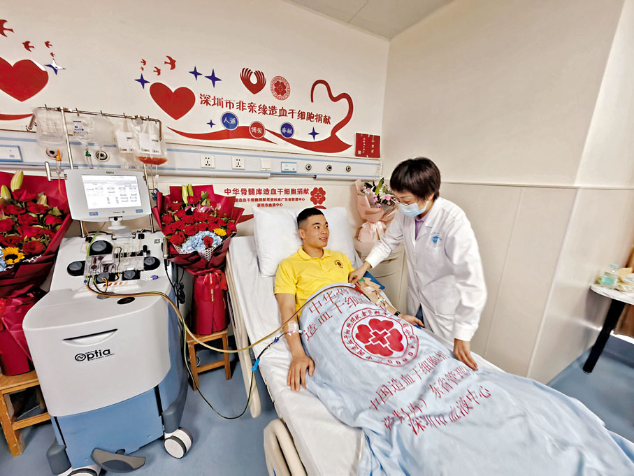 ◆中華骨髓庫深圳工作站專職聯絡員張宏（右）向捐髓者小梁了解情況。香港文匯報記者郭若溪  攝