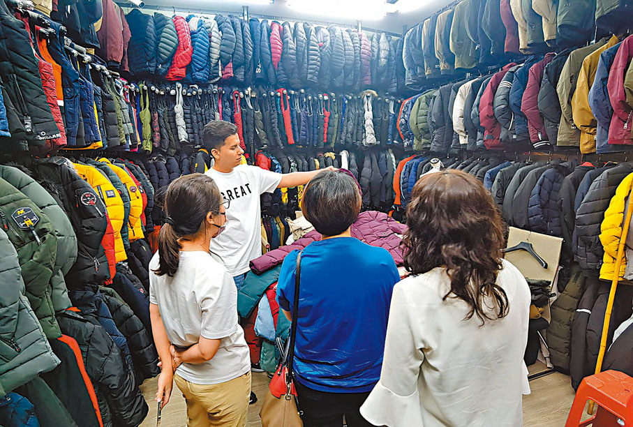 ◆中東商人阿里在石獅服裝城檔口向客戶介紹產品。