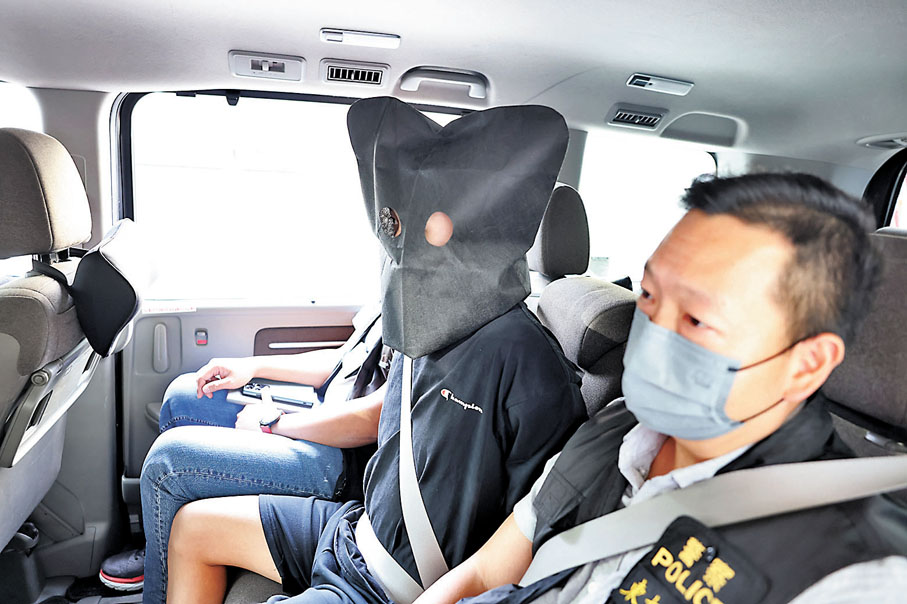 ◆越南籍疑犯被黑布蒙頭及鎖上手銬押署。香港文匯報記者鄺福強 攝