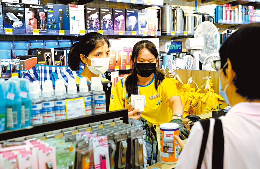 ◆店長甘麗鳳（左）與同樣來自珠海的員工正服務顧客。香港文匯報記者劉明 攝