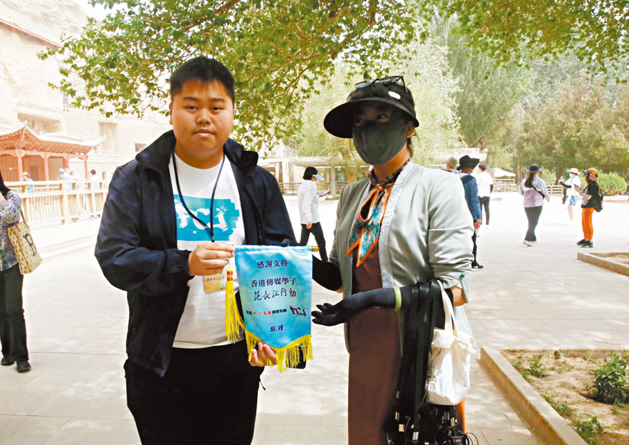 ◆採訪團成員向莫高窟講解員贈送旗幟表示感謝。 