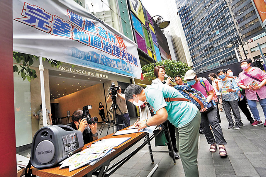 ◆有調查發現近九成市民認同加入委任制及地區委員會界別，有助多渠道廣納各界精英參與區議會工作。圖為市民於街站簽名支持方案。資料圖片