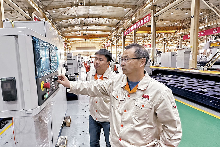 ◆張揚（左）跟師父嚴昊明（右）在數控機床操作台調試。 香港文匯報記者于珈琳 攝