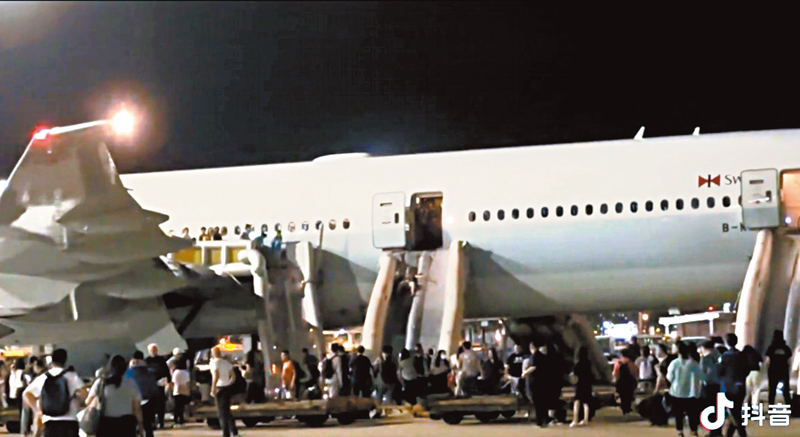 ◆大批乘客沿逃生梯滑到地面。