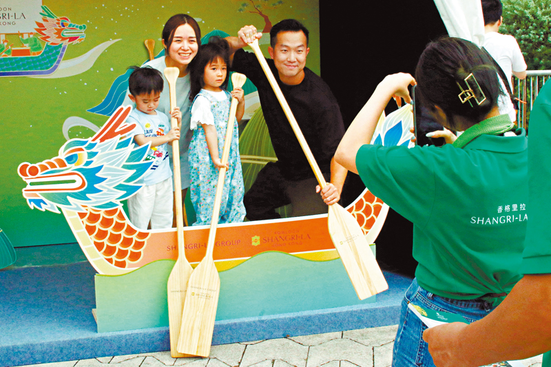 ◆市民模仿划龍舟拍照留念。香港文匯報記者北山彥  攝