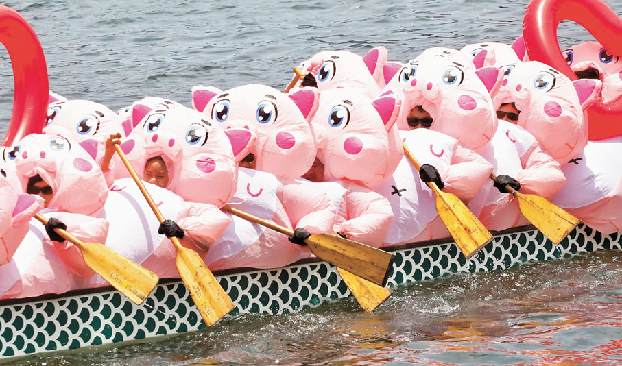 ◆有隊伍扮演粉紅充氣豬，遠看像一群小胖豬在划龍舟。香港文匯報記者郭木又  攝