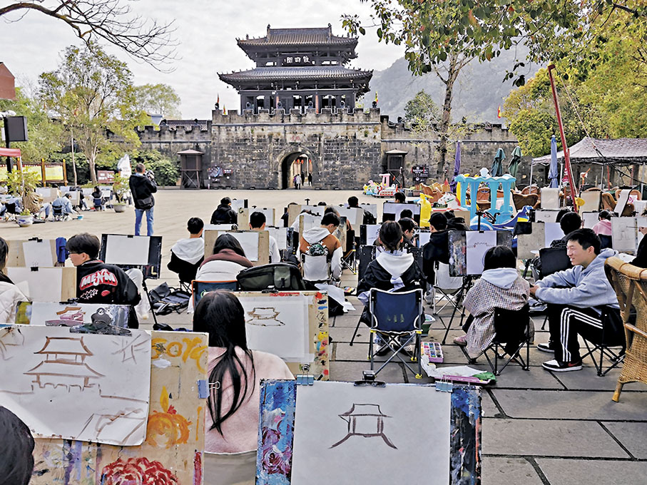 ◆學生們在戰勝壩上臨摹昭化古城城門。