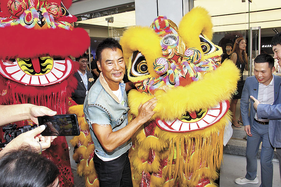 ◆華哥欣賞舞獅表演之餘，也去攬獅頭拿好意頭。