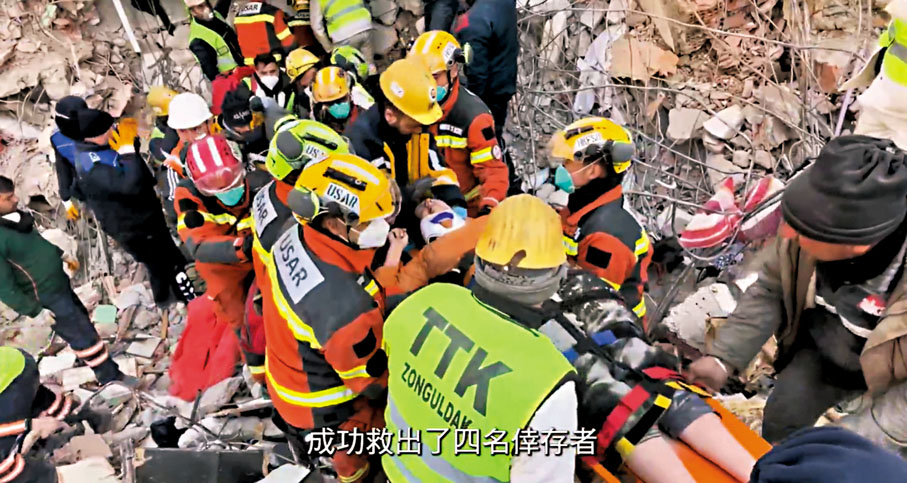 ◆香港特區救援隊與其他救援人員當日合力在瓦礫中用擔架抬出一名生還者。 視頻截圖
