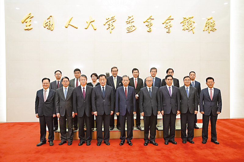 ◆全國人大常委會委員長趙樂際昨日向第六任全國人大常委會香港特別行政區基本法委員會組成人員和第五任全國人大常委會澳門特別行政區基本法委員會新任委員頒發任命書。圖為頒發任命書後趙樂際等與上述人員合影。 新華社