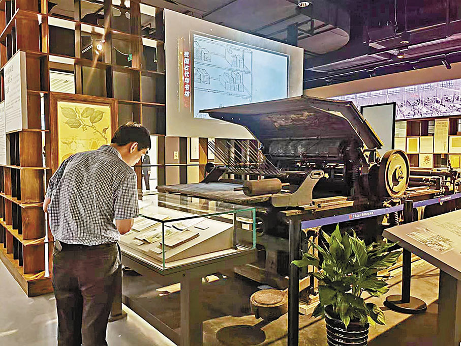 ◆擁有百年歷史的石印機印出的作品吸引了遊客目光。香港文匯報記者 倪夢璟  攝