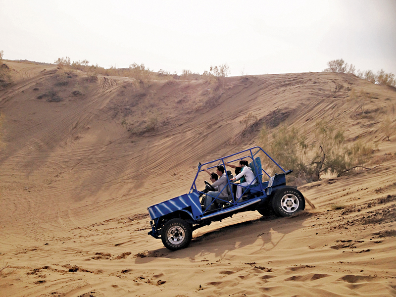 ◆遊客在新疆體驗沙漠越野衝浪。
