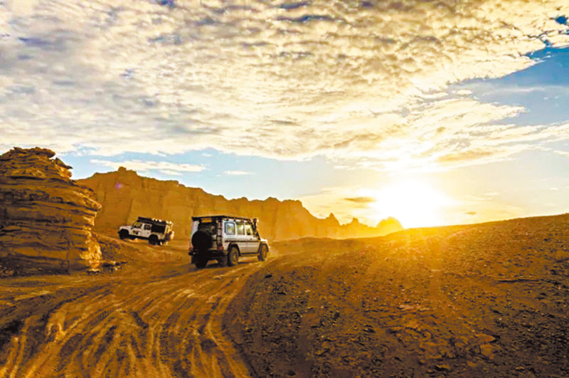 ◆遊客駕車穿行在新疆哈密翼龍雅丹大海道景區。
