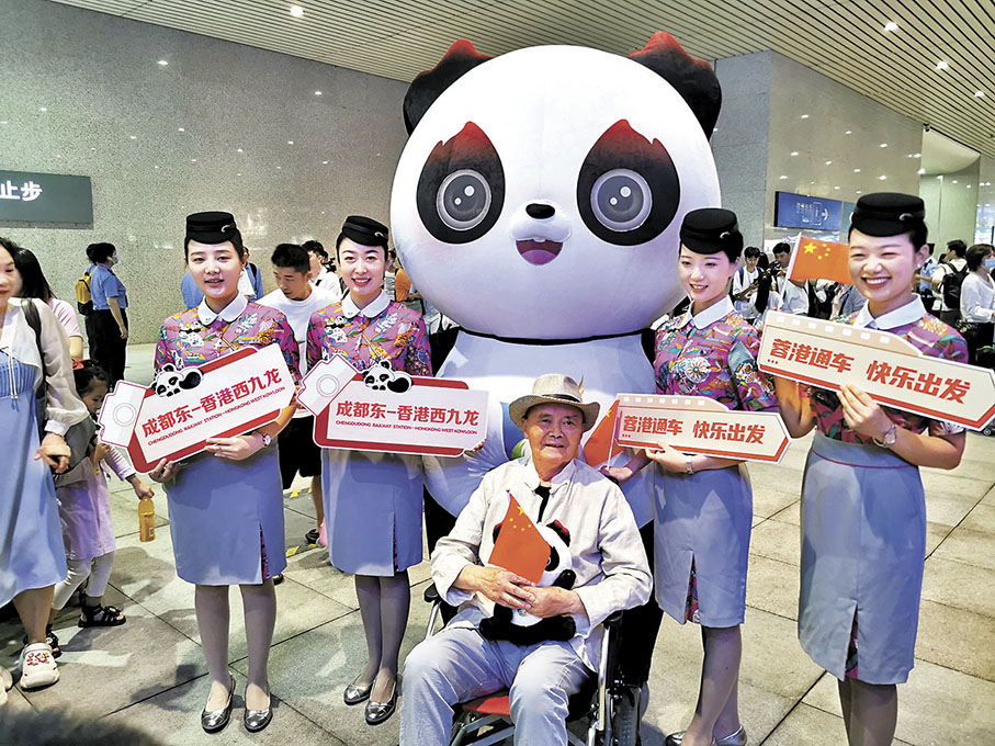 ◆旅客和乘務人員、成都大運會吉祥物「蓉寶」合影。 香港文匯報記者向芸  攝
