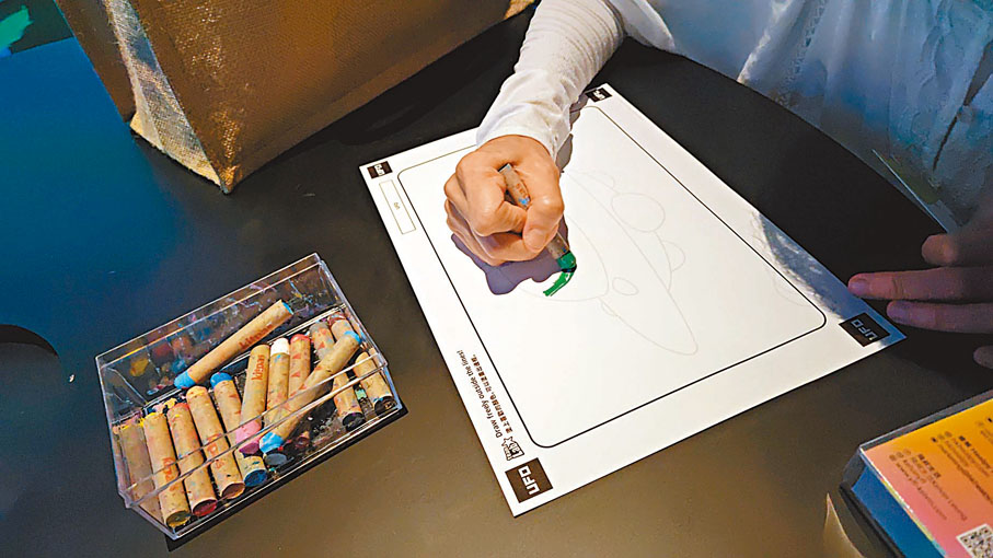 ◆參觀者可在紙上畫好有關城鎮的圖畫後，掃描後就會出現在城鎮中。