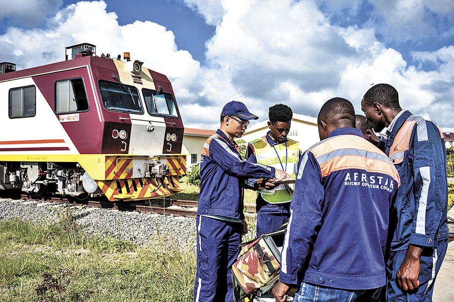 ◆ 自改革開放以來，中國積極參與國際事務，成為全球治理及多邊合作的重要一員。圖為中國鐵路專家在肯尼亞內羅畢與當地員工檢查儀器。 資料圖片