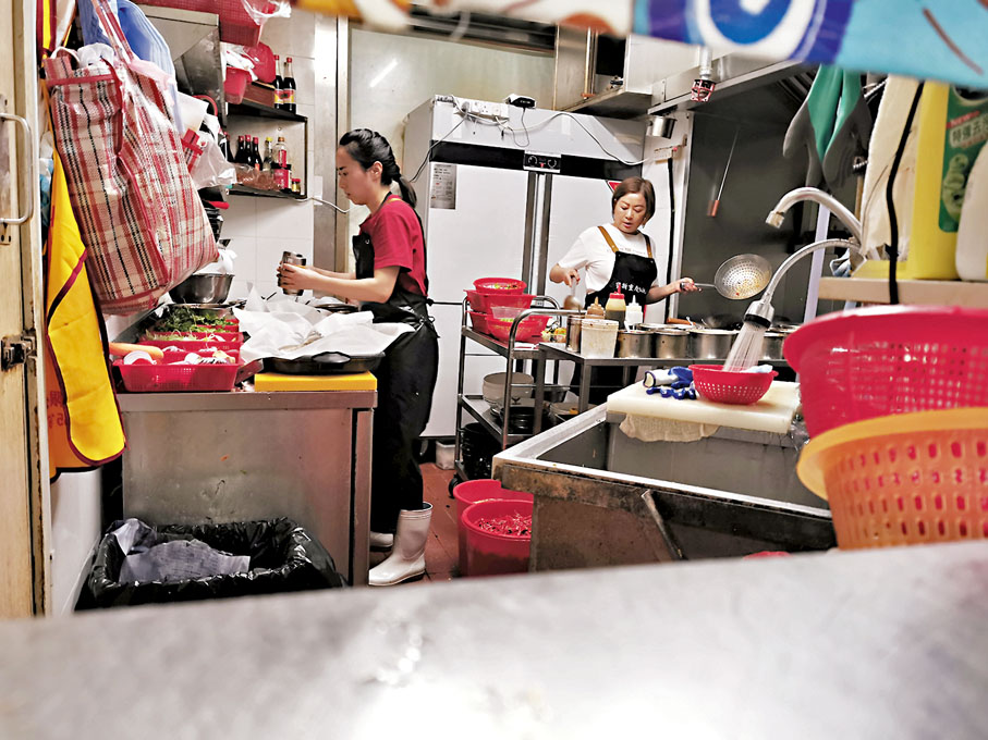 ◆秀姐（右）親自掌廚，兩個女士在炮製紙包魚。