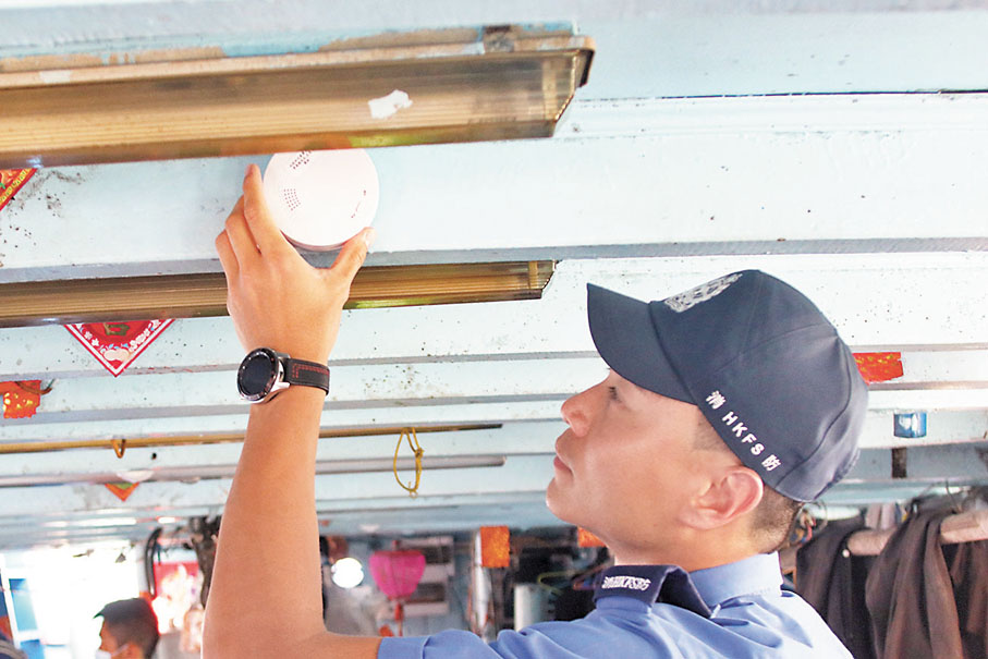 ◆消防處人員協助船主安裝獨立火警偵測器。香港文匯報記者北山彥 攝
