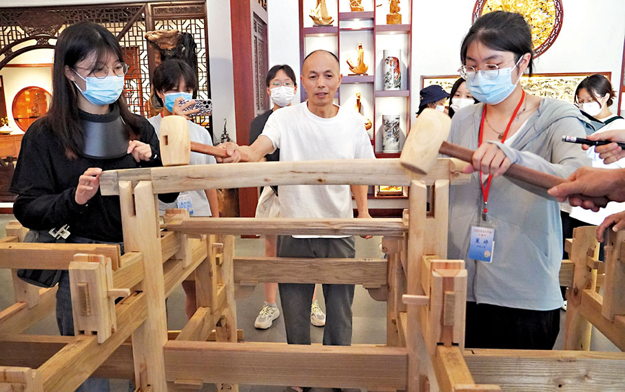 ◆傳媒學子在體驗中國傳統建築裏榫卯結構拼裝。 香港文匯報記者王逍  攝