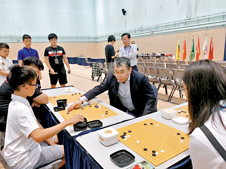 ◆來港出席香港國際大學生圍棋公開賽的聶衛平，指導年輕人對弈。