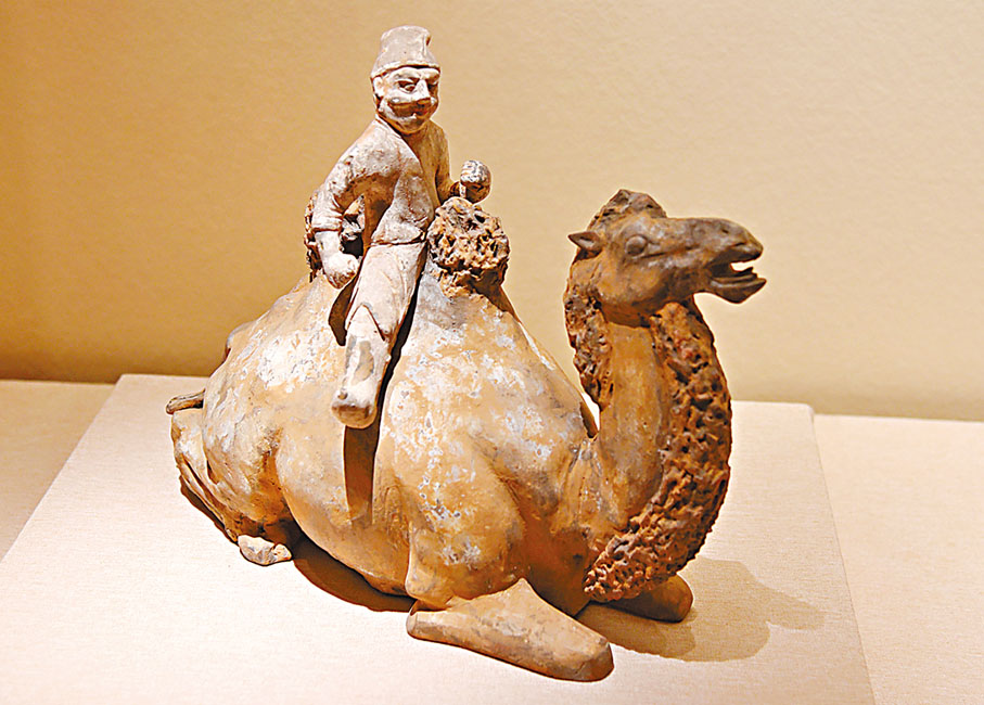 ◆長安西市匯聚各國商賈，商品琳琅滿目。圖為唐彩繪胡人騎臥駝俑。