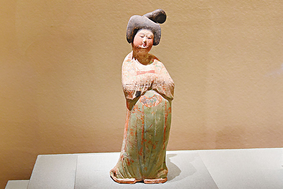 ◆唐時社會風氣開放包容，女性遊春成為長安一道明麗風景。圖為唐墜馬髻女立俑。