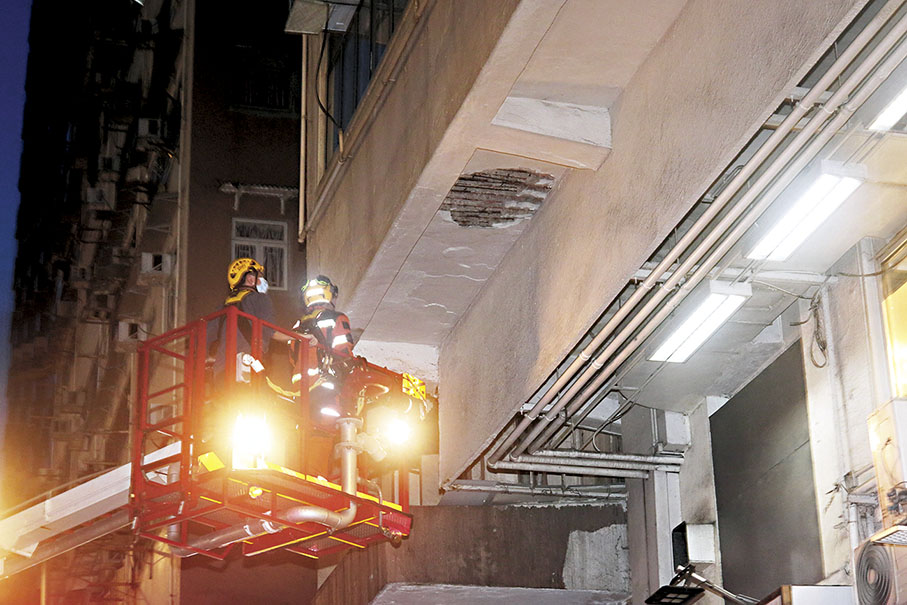 ◆消防員架起升降台檢查大廈石屎剝落位置。