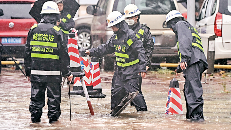 ◆7月18日，颱風「泰利」在廣西沿海再次登陸，廣西欽州市城管工作人員在文峰路排澇。新華社