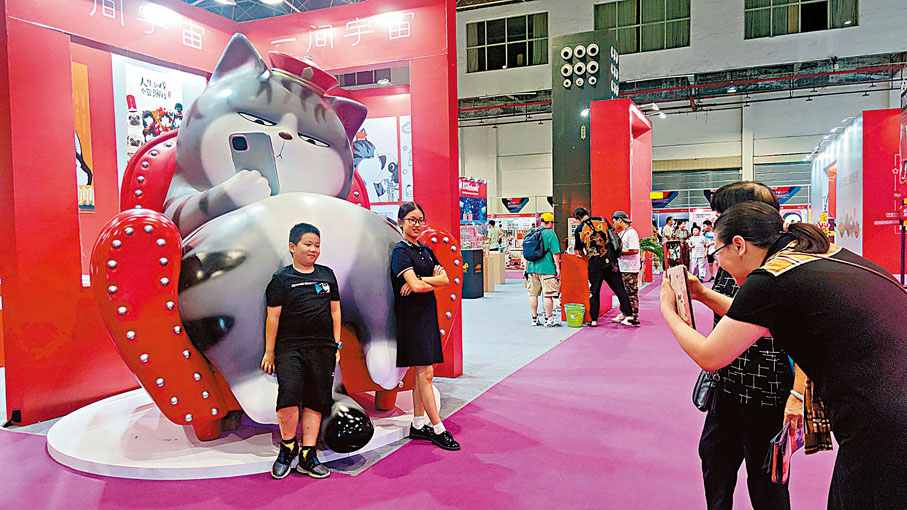 ◆ 兩個小朋友和巨型的「吾皇」貓咪合照。香港文匯報記者盧靜怡  攝