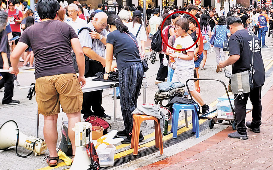 ◆昨日（23日），李盈姿（紅圈）參與社民連在銅鑼灣一帶的街站活動，不僅幫忙派傳單，在活動結束時亦幫手收拾物資。 香港文匯報記者  攝