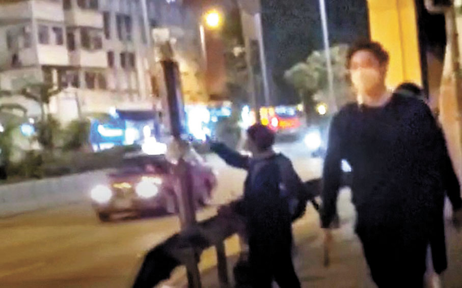 ◆今年2月，李盈姿（左一）在九龍灣四處鬼祟貼街招後快速離去。 資料圖片